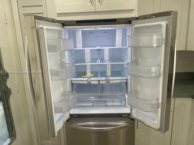 room details featuring white cabinetry and refrigerator