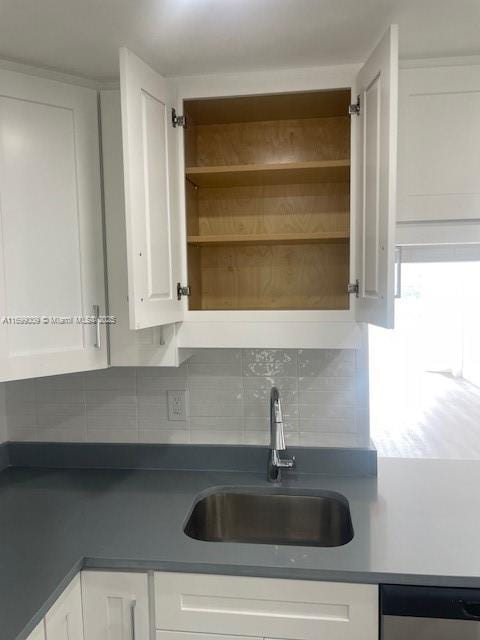 kitchen featuring white cabinetry, stainless steel dishwasher, sink, and tasteful backsplash