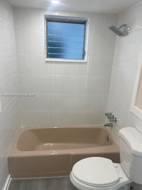 bathroom with tiled shower / bath and toilet