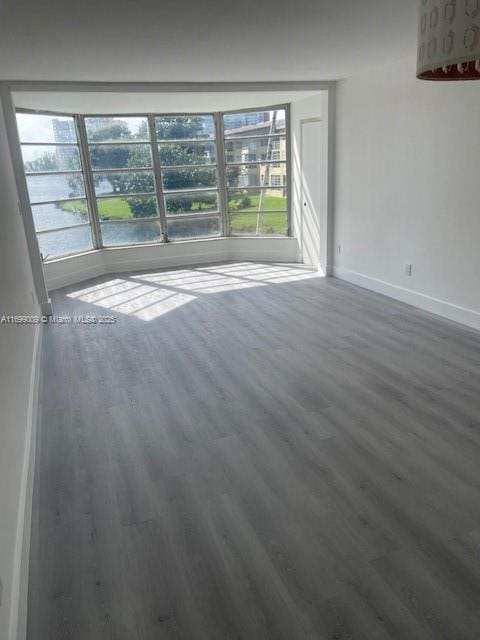 empty room with dark hardwood / wood-style flooring