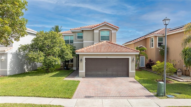 mediterranean / spanish home with a garage and a front lawn