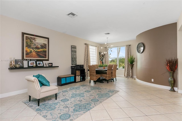 living area with light tile patterned flooring and an inviting chandelier