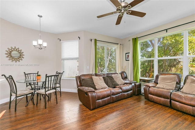 living room with dark wood-type flooring, a healthy amount of sunlight, and ceiling fan with notable chandelier