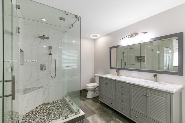 bathroom with walk in shower, vanity, and toilet