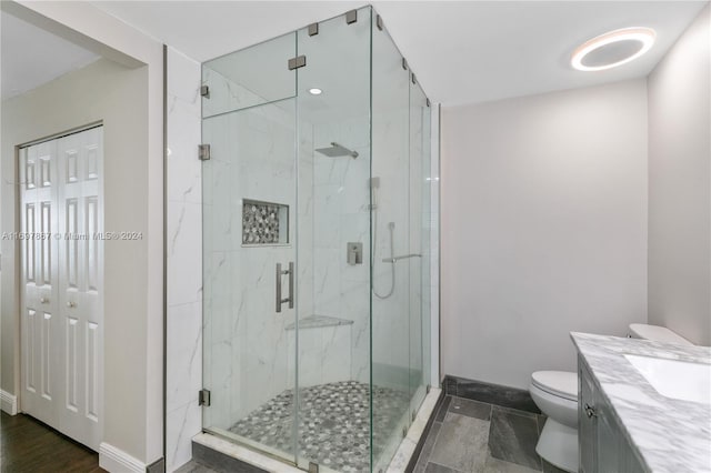 bathroom with vanity, a shower with shower door, and toilet