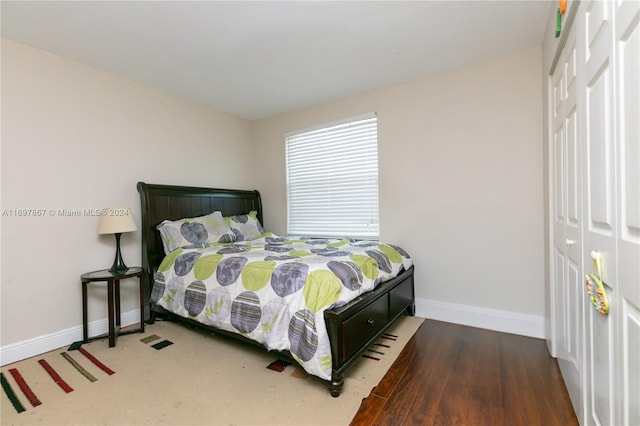 bedroom featuring dark hardwood / wood-style flooring and a closet