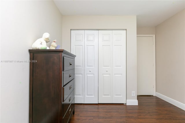 unfurnished bedroom with dark hardwood / wood-style flooring and a closet