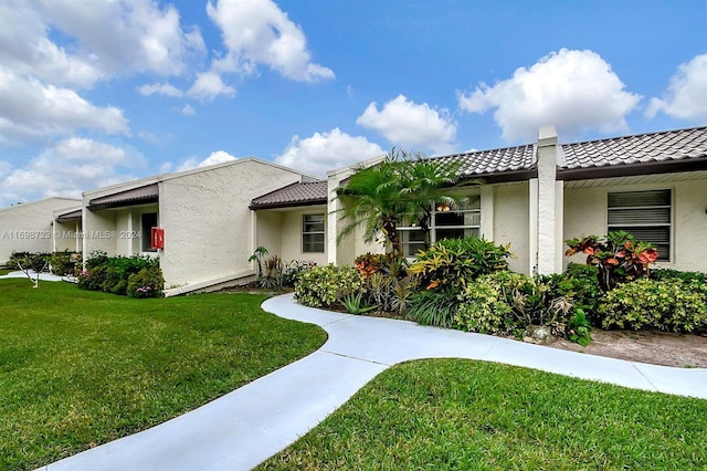 mediterranean / spanish-style house with a front lawn