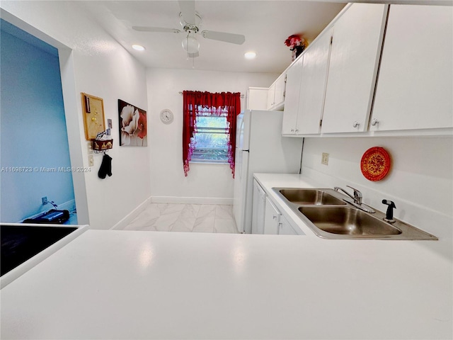 kitchen featuring white refrigerator, white cabinetry, ceiling fan, and sink