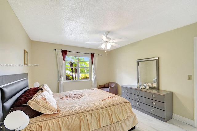 bedroom with ceiling fan and a textured ceiling