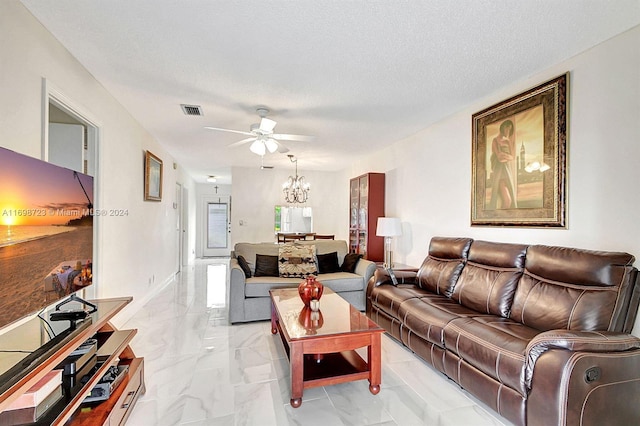 living room with ceiling fan with notable chandelier and a textured ceiling