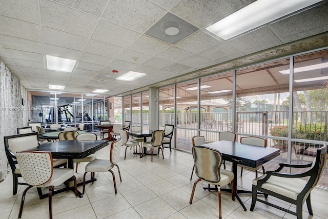 dining area with a wealth of natural light, a drop ceiling, and light tile patterned floors