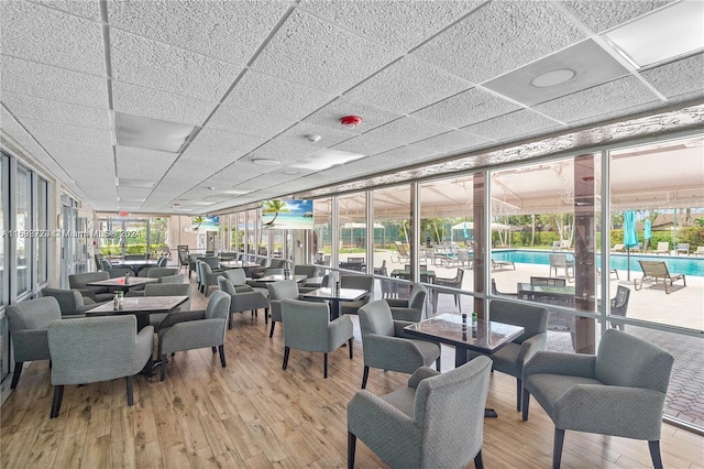 dining space with a paneled ceiling and light hardwood / wood-style flooring