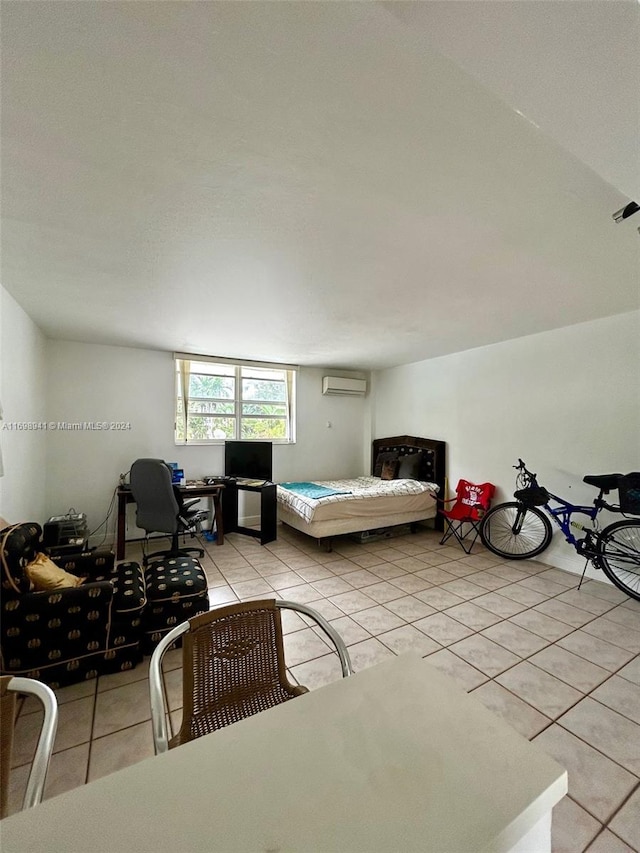 bedroom featuring light tile patterned floors and an AC wall unit