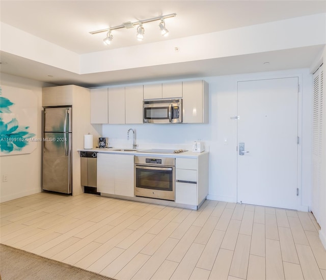 kitchen featuring white cabinetry, sink, appliances with stainless steel finishes, and light hardwood / wood-style flooring