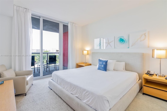 bedroom with access to exterior, light carpet, and a wall of windows