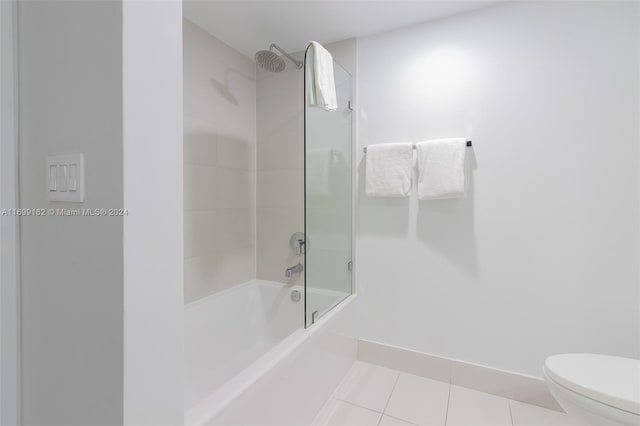 bathroom with toilet, tile patterned floors, and tiled shower / bath