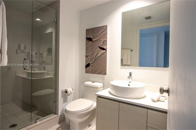 bathroom with a shower with door, vanity, and toilet