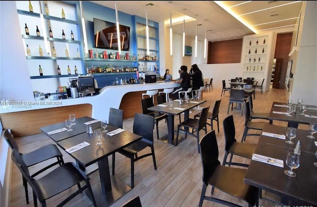 dining area featuring bar area and light hardwood / wood-style floors