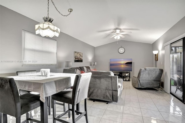 tiled dining room with ceiling fan and vaulted ceiling