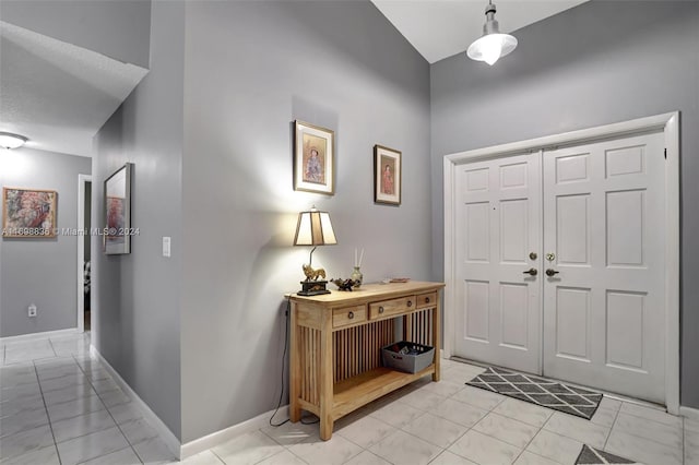 tiled entryway featuring vaulted ceiling