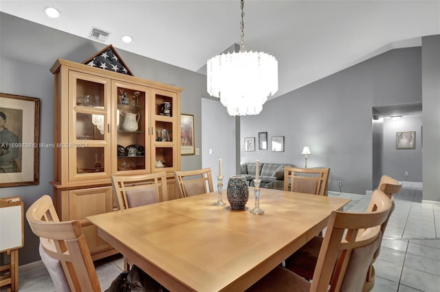 tiled dining area featuring vaulted ceiling and a notable chandelier