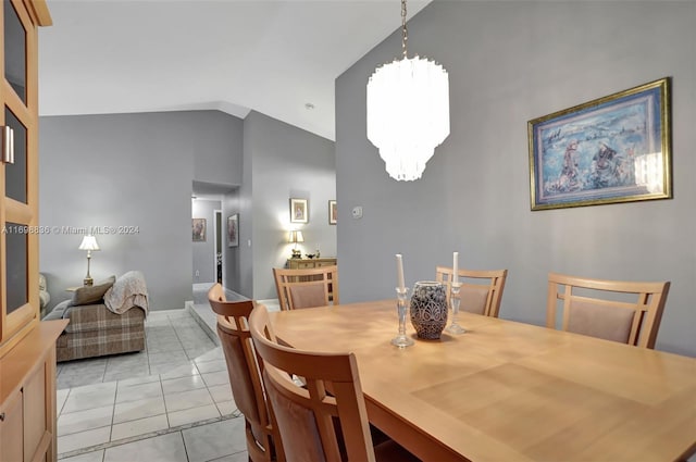 tiled dining room with high vaulted ceiling and an inviting chandelier