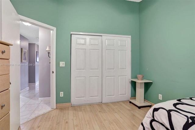 bedroom with light wood-type flooring and a closet