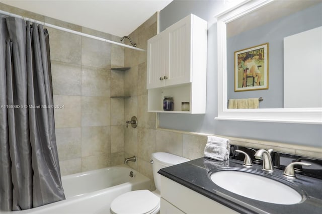 full bathroom featuring shower / bath combination with curtain, vanity, toilet, and tile walls