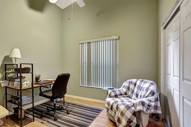 office area featuring a high ceiling, hardwood / wood-style flooring, and ceiling fan