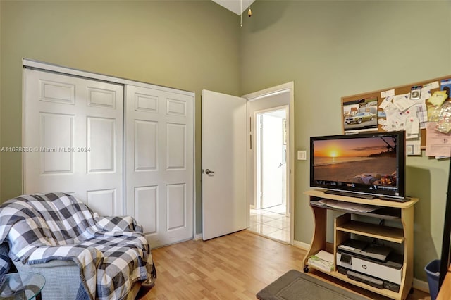 living room featuring light hardwood / wood-style flooring and a towering ceiling