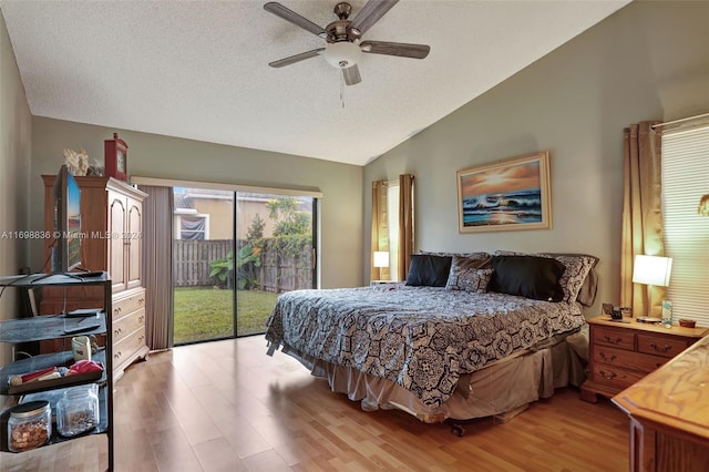 bedroom with ceiling fan, light hardwood / wood-style floors, access to exterior, and lofted ceiling