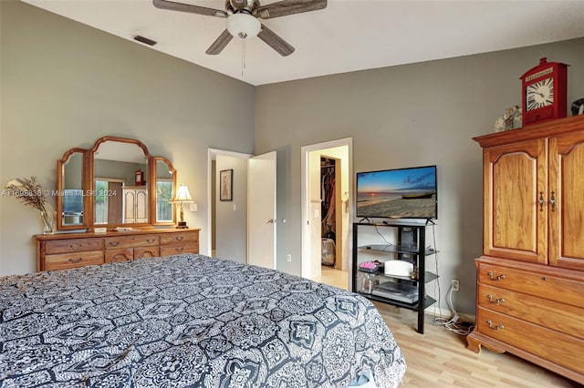 bedroom with a closet, a walk in closet, ceiling fan, and light hardwood / wood-style flooring