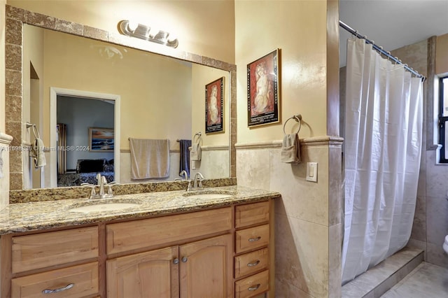 bathroom featuring a shower with shower curtain, vanity, and tile walls