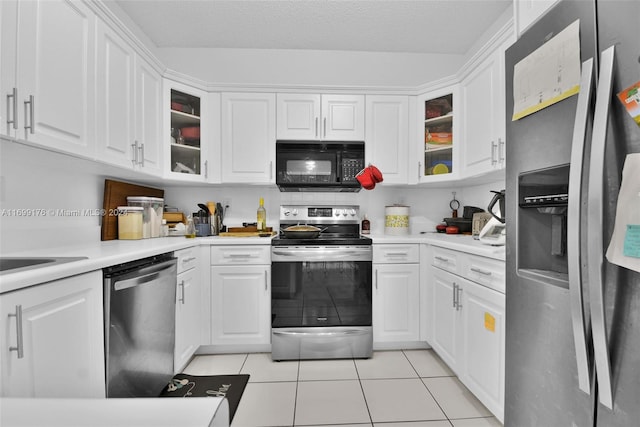 kitchen featuring a textured ceiling, white cabinets, light tile patterned floors, and appliances with stainless steel finishes