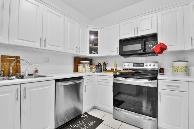 kitchen with sink, appliances with stainless steel finishes, tasteful backsplash, light tile patterned flooring, and white cabinetry