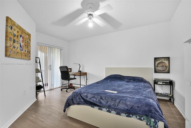 bedroom featuring hardwood / wood-style flooring, ceiling fan, and a textured ceiling