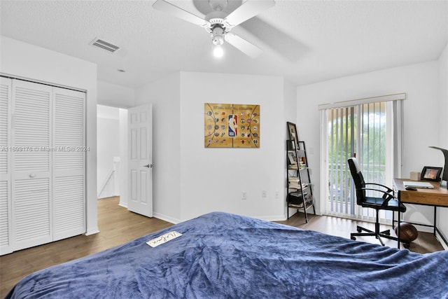 bedroom featuring access to exterior, a textured ceiling, ceiling fan, hardwood / wood-style flooring, and a closet