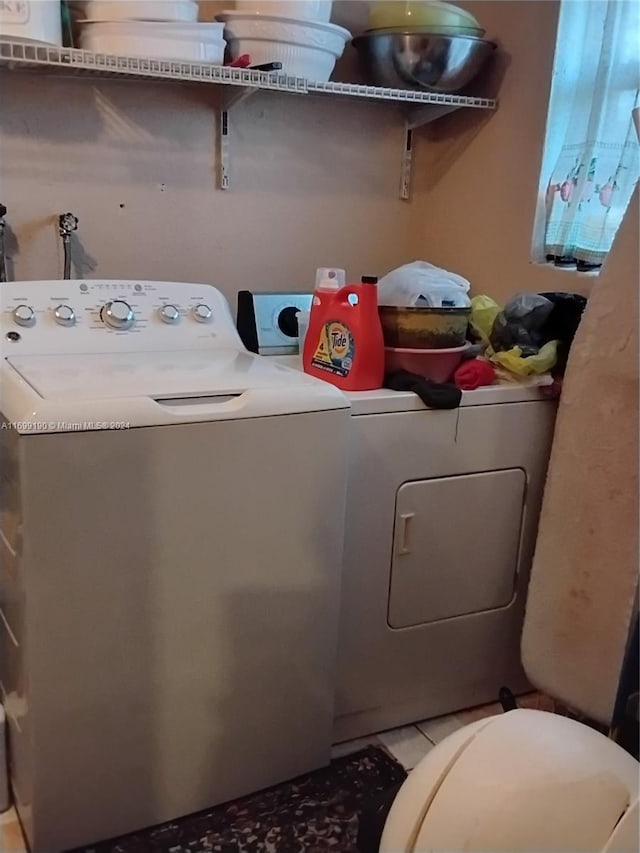 clothes washing area featuring independent washer and dryer and light tile patterned floors