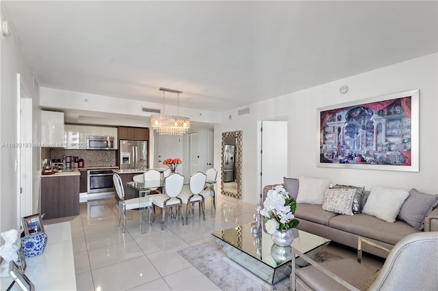 tiled living room featuring an inviting chandelier