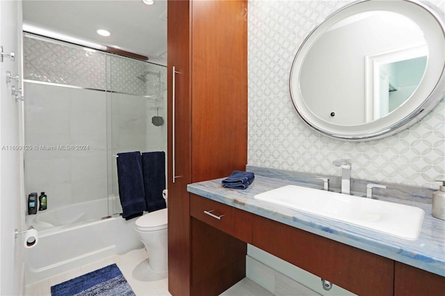 full bathroom with tile patterned flooring, vanity, toilet, and bath / shower combo with glass door