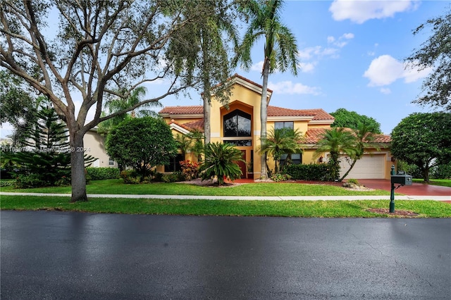 mediterranean / spanish-style home with a front lawn and a garage