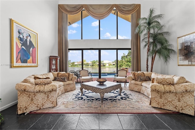 living room with a towering ceiling and a water view