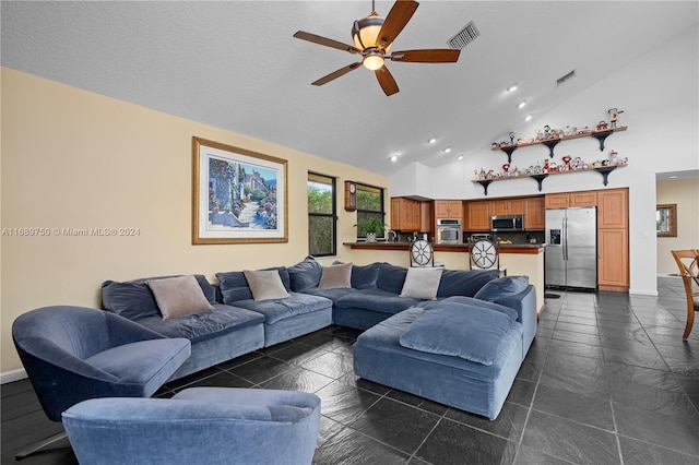 living room with a textured ceiling, high vaulted ceiling, and ceiling fan