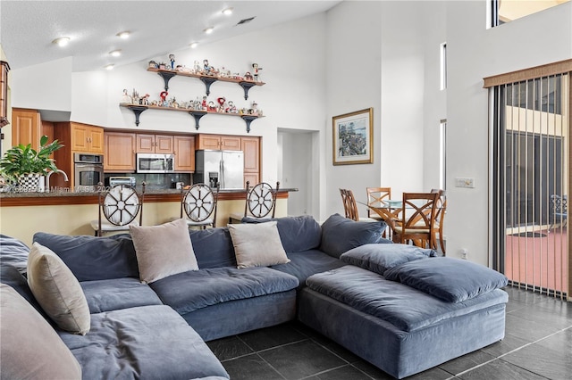 tiled living room with high vaulted ceiling and a textured ceiling