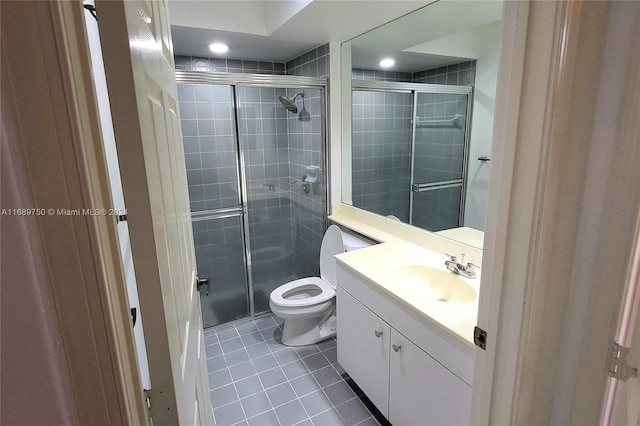 bathroom with tile patterned flooring, vanity, toilet, and walk in shower