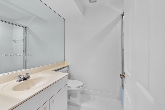 bathroom with tile patterned floors, vanity, toilet, and walk in shower