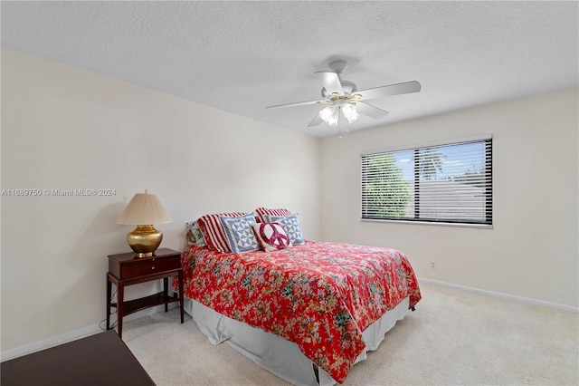 carpeted bedroom featuring ceiling fan and a textured ceiling