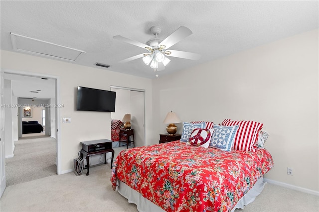 carpeted bedroom with ceiling fan, a closet, and a textured ceiling