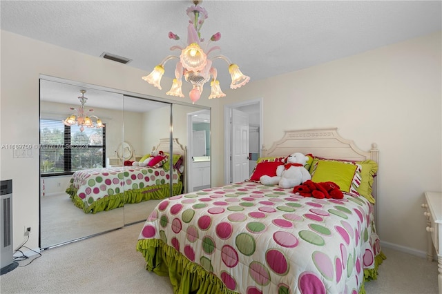 bedroom with carpet, an inviting chandelier, a textured ceiling, and a closet